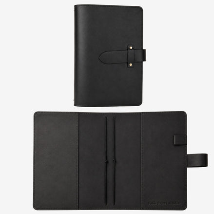 A black leather planner or notebook cover shown in two views: closed with a strap closure at the top, and open to reveal interior pockets and a strap tab on the right side. The brand name 'rusty russia studio' is subtly printed in the bottom right corner of the open cover.